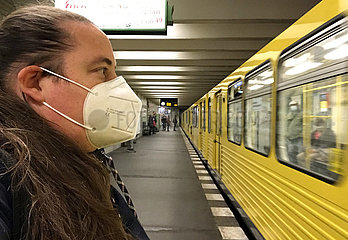 Berlin  Deutschland  Frau auf einem U-Bahnhof traegt in Zeiten der Coronapandemie einen Mund-Nasen-Schutz
