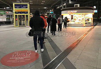 Berlin  Deutschland  Menschen stehen in Zeiten der Coronapandemie auf dem Bahnhof Suedkreuz mit Abstand zueinander an einem Backshop an