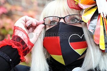Hoppegarten  Deutschland  Frau traegt einen selbstgenaehten Mund-Nasen-Schutz in den deutschen Nationalfarben
