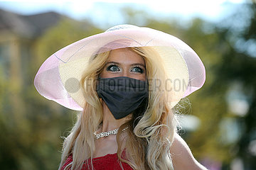 Iffezheim  Deutschland  Fashion: Elegant gekleidete Frau mit Hut traegt Mund-Nasen-Schutz