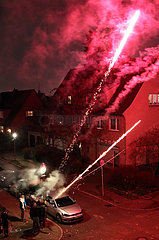 Berlin  Deutschland  Menschen schiessen auf der Strasse Roemische Lichter in den Himmel