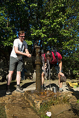 Republik Moldau  Orheiul Vechi - Touristen schoepfen Wasser aus alter Schwengelpumpe an einem heissen Tag  beim Orheiul-Vechi-Komplex  einem historischen Siedlungsgebiet