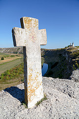 Republik Moldau  Orheiul Vechi - Kreuz beim Orheiul-Vechi-Komplex  einem historischen Siedlungsgebiet  hinten das Kloster von Orheiul Vechi