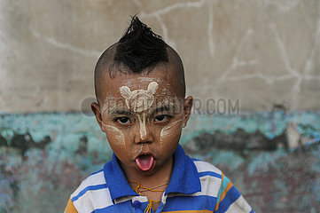 Yangon  Myanmar  Portrait eines kleinen Jungen mit Thanakapaste Make-up im Gesicht