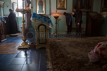 Republik Moldau  - Das erste Gebet am Morgen in der Kirche des Klosters Tipova bei Sonnenaufgang  der Pope steht bei der Ikonostase