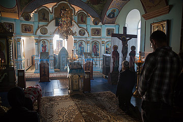Republik Moldau  - Das erste Gebet am Morgen in der Kirche des Klosters Tipova bei Sonnenaufgang  der Pope steht bei der Ikonostase