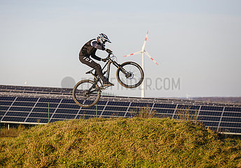 Mountainbikefahrer auf Mountainbike Arena vor Solarpark und Windrad  Dortmund  Ruhrgebiet  Nordrhein-Westfalen  Deutschland
