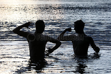 Dranse  Deutschland  Silhouette: Jugendliche stehen im Wasser eines Sees und posieren