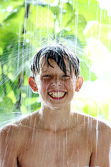 Pomantello  Italien  Junge kuehlt sich im Freien unter einer Dusche ab