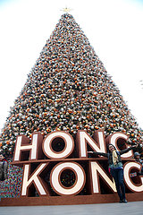 Hong Kong  China  Frau steht vor einem riesigen Weihnachtsbaum aus unzaehligen Christbaumkugeln und dem Schriftzug Hong Kong