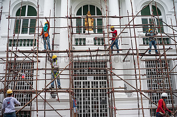 Singapur  Republik Singapur  Arbeiter bauen auf einer Baustelle ein hoelzernes Baugeruest ab