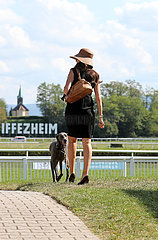 Iffezheim  Deutschland  Fashion: elegant gekleidete Frau mit Hund auf der Galopprennbahn