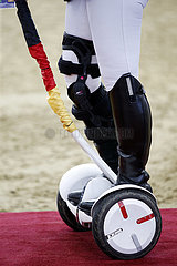 Doha  Reiter mit Knieorthese bewegt sich auf einem Elektro-Scooter vorwaerts