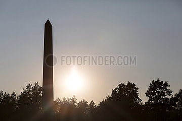 Deutschland  Lohheide - Gedenkstaette Bergen-Belsen  Obelisk in der Abendsonne