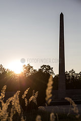 Deutschland  Lohheide - Gedenkstaette Bergen-Belsen  Obelisk in der Abendsonne