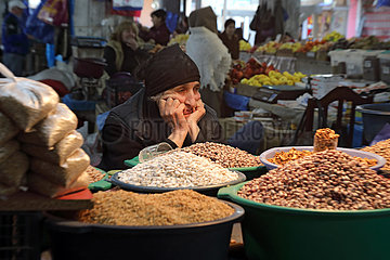 Kutaissi  Georgien  Nusshaendlerin auf einem Wochenmarkt wartet auf Kundschaft