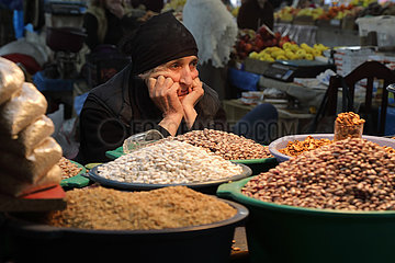 Kutaissi  Georgien  Nusshaendlerin auf einem Wochenmarkt wartet auf Kundschaft