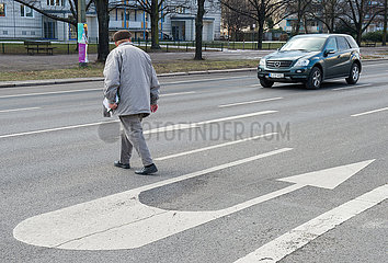 Berlin  Deutschland - Senior beim Ueberqueren einer mehrspurigen Strasse