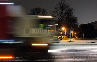 Berlin  Deutschland  Dynamik: LKW faehrt in der Nacht auf einer mit Schnee bedeckten Strasse