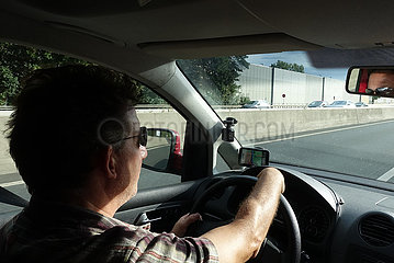 Bad Homburg  Deutschland  Mann mit Sonnenbrille faehrt in seinem Wagen entspannt auf der Autobahn