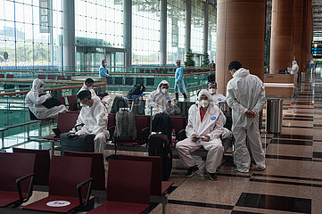 Singapur  Republik Singapur  Flugreisende tragen Masken und Schutzanzuege am Flughafen Changi