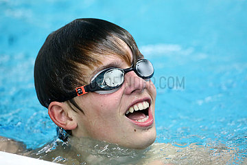 Berlin  Deutschland  Jugendlicher lacht beim Schwimmen im Hallenbad