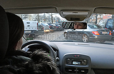 Berlin  Deutschland  Frau wartet im Auto auf einen Parkplatz