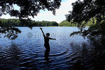 Walkmuehle  Deutschland  Silhouette  Frau post beim Baden in einem See
