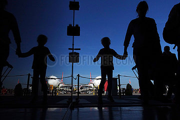 Berlin  Deutschland  Silhouette eines alleinreisenden Kindes mit Begleitperson auf dem Weg vom Flugzeug zum Terminal am Flughafen Berlin-Tegel