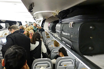Helsinki  Finnland  Menschen in einer Flugzeugkabine verstauen vor dem Abflug ihr Handgepaeck