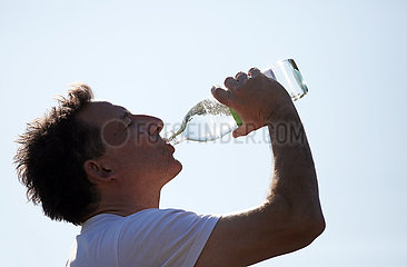 Ingelheim  Deutschland  Mann trinkt Wasser aus einer Glasflasche