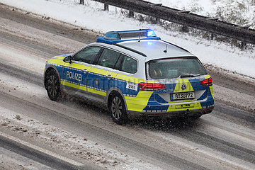 Berlin  Deutschland  Polizeiauto bei Schneefall auf Einsatzfahrt