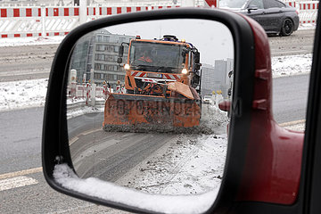 Berlin  Deutschland  Winterdienst der BSR spiegelt sich beim Raeumen einer Strasse im linken Seitenspiegel eines PKW