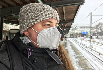 Berlin  Deutschland  Frau mit Muetze traegt im Winter auf einem S-Bahnhof eine FFP2-Maske