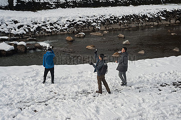 Takayama  Japan  Gruppe von Maennern bei einer Schneeballschlacht am Miyagawa Fluss