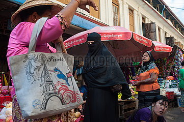 Yangon  Myanmar  Frauen kaufen auf einem Strassenmarkt Lebensmittel ein