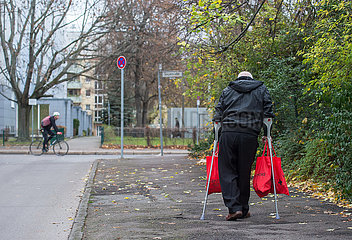 Berlin  Deutschland - Senior mit Gehhilfen und Einkaufstauschen