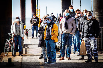 HVV Fahrgäste mit Masken an der Elbe