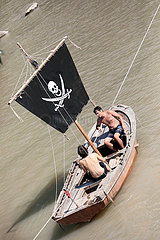 Keda  Georgien  Maenner sitzen in einem Boot mit Piratenflagge