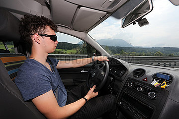 Kufstein  Oesterreich  junger Mann faehrt Auto auf der A12