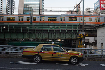 Tokio  Japan  Stadtbild mit Taxi  Gebaeuden und Pendlerzug im Bezirk Chiyoda