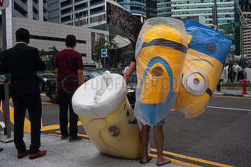 Singapur  Republik Singapur  Mann wartet mit Minions-Kostuemen an einer Ampel im Stadtzentrum