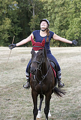 Gestuet Westerberg  junge Frau sitzt gluecklich und mit ausgebreiteten Armen auf ihrem Pferd