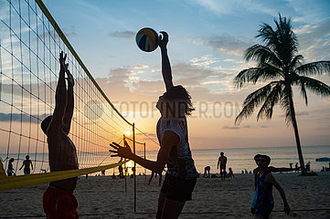 Phuket  Thailand  Einheimische spielen am Strand von Karon Beach Volleyball im Sonnenuntergang