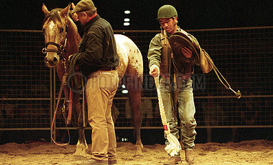Berlin  Monty Roberts (links) und Jason Davis gewoehnen ein Pferd an einen Sattel