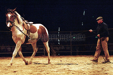 Berlin  Monty Roberts longiert ein Pferd mit Sattel