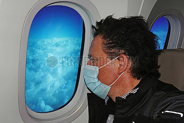 Riad  Saudi-Arabien  Mann mit Mund-Nasen-Schutz schaut aus einem Flugzeugfenster