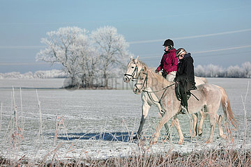 Bruchmuehle  Frauen machen im Winter bei Schnee einen Ausritt