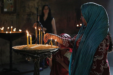 Mzcheta  Georgien  Frau zuendet in der Swetizchoweli-Kathedrale eine Kerze an