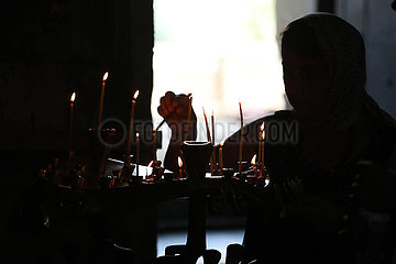 Mzcheta  Georgien  Silhouette: Frau zuendet in der Swetizchoweli-Kathedrale eine Kerze an